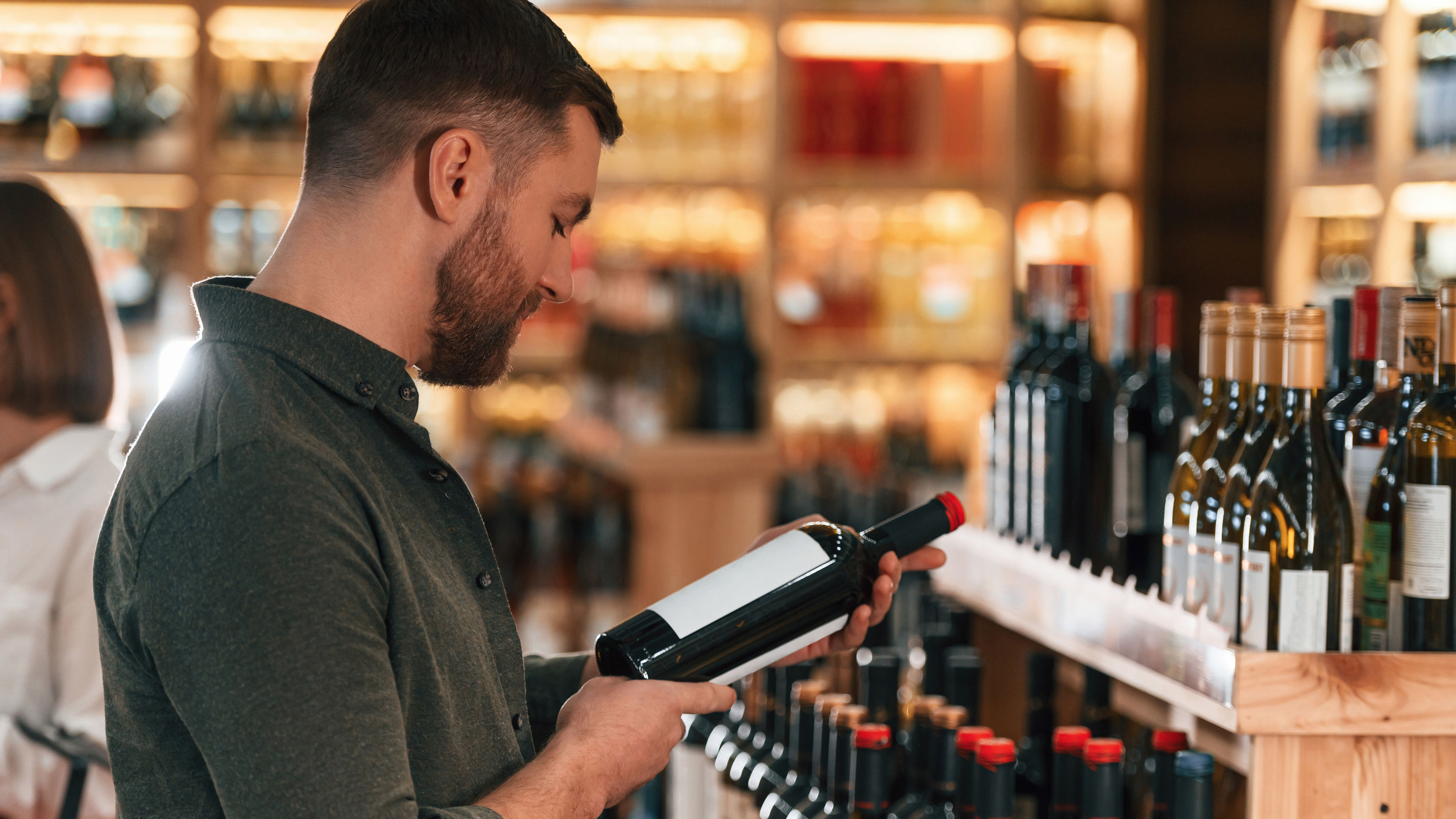 Man and woman are choosing wine in the shop.