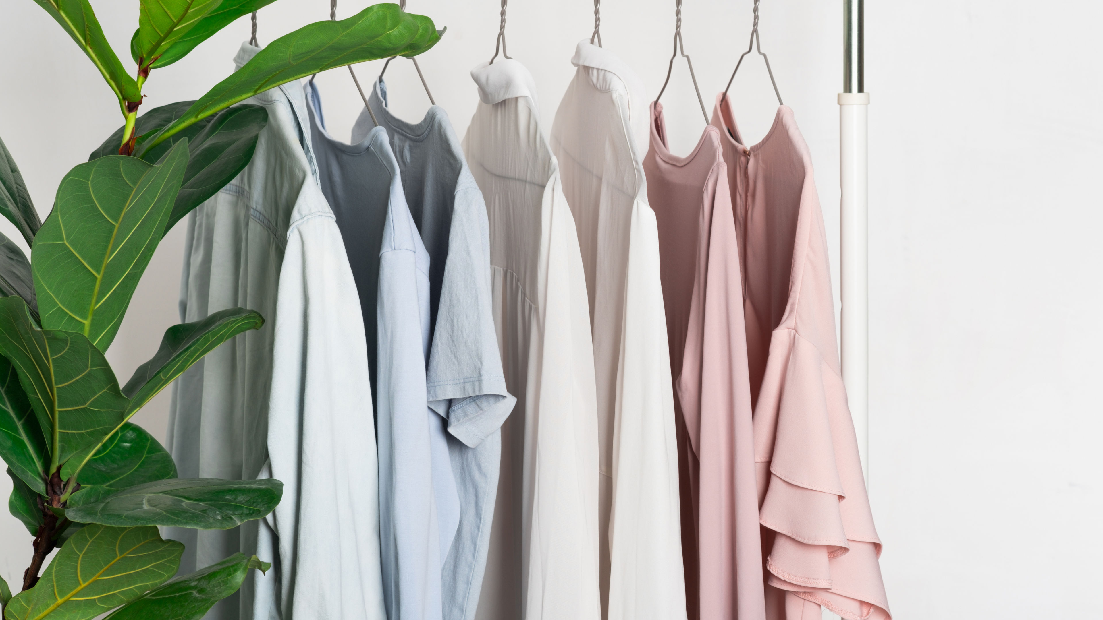 A clothing rack displaying pastel-colored linen tops 