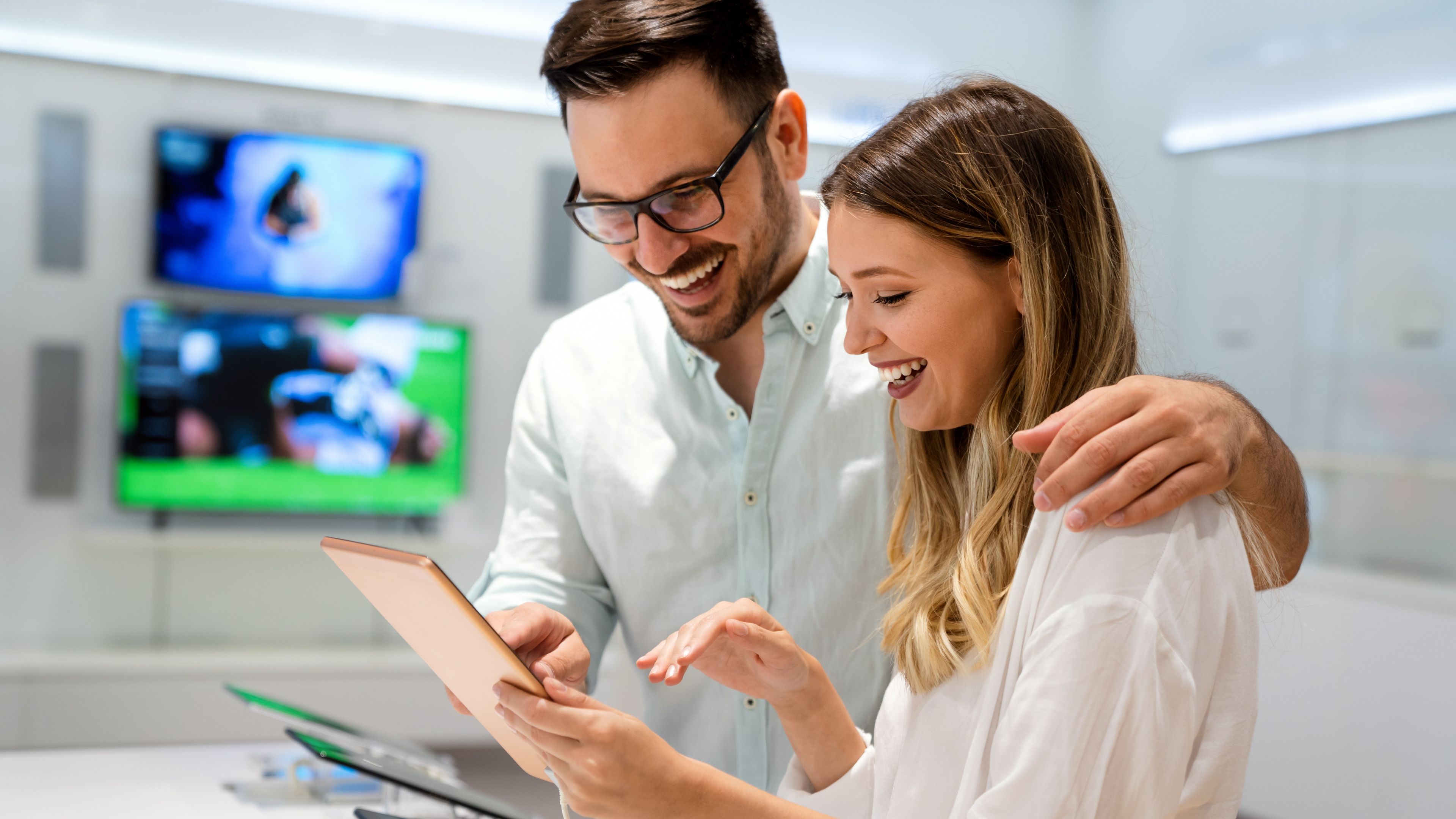 A couple smiling and using the iPad