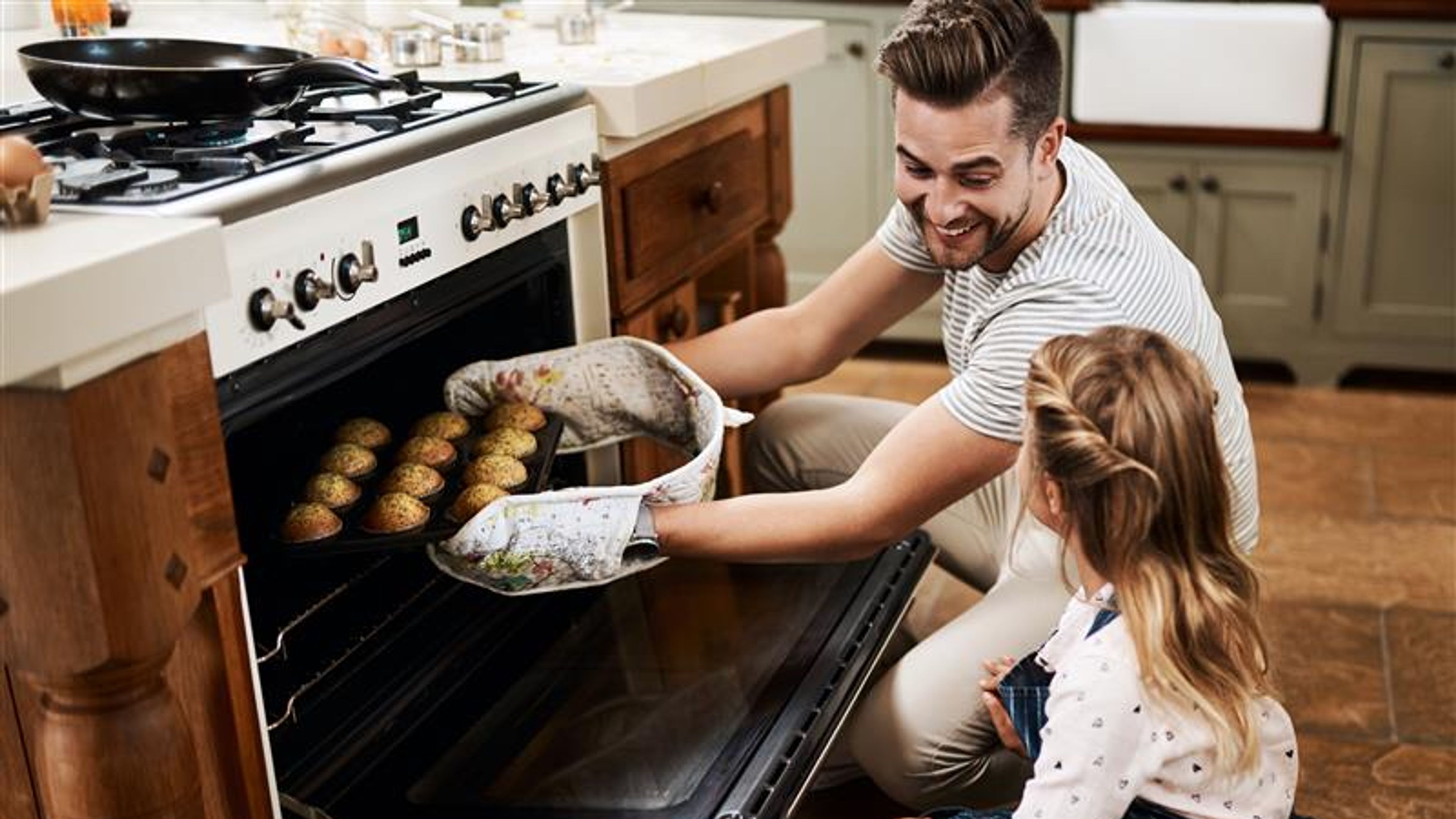A father and a daughter cooking together.