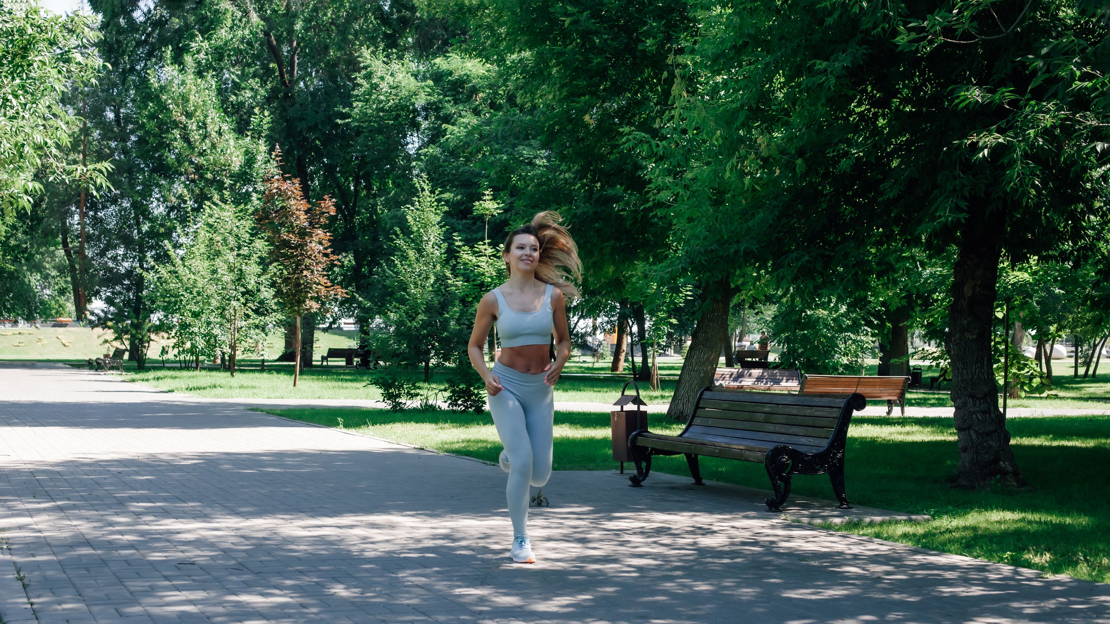 A fit woman is jogging along a park path