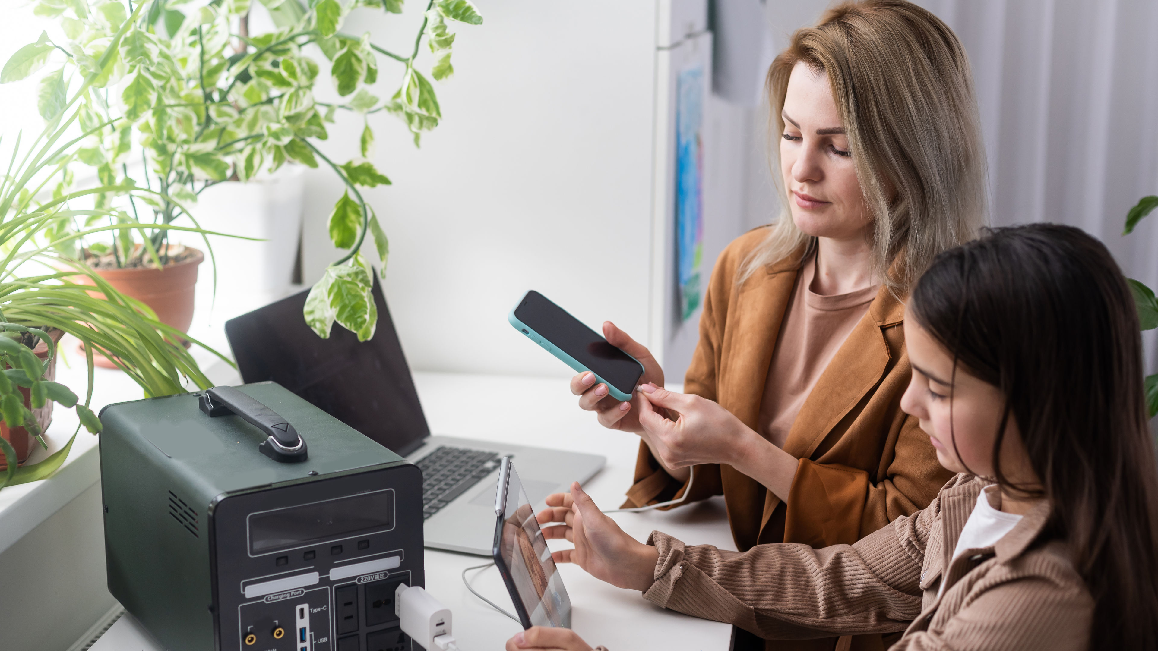A girl and her mom using portable charger