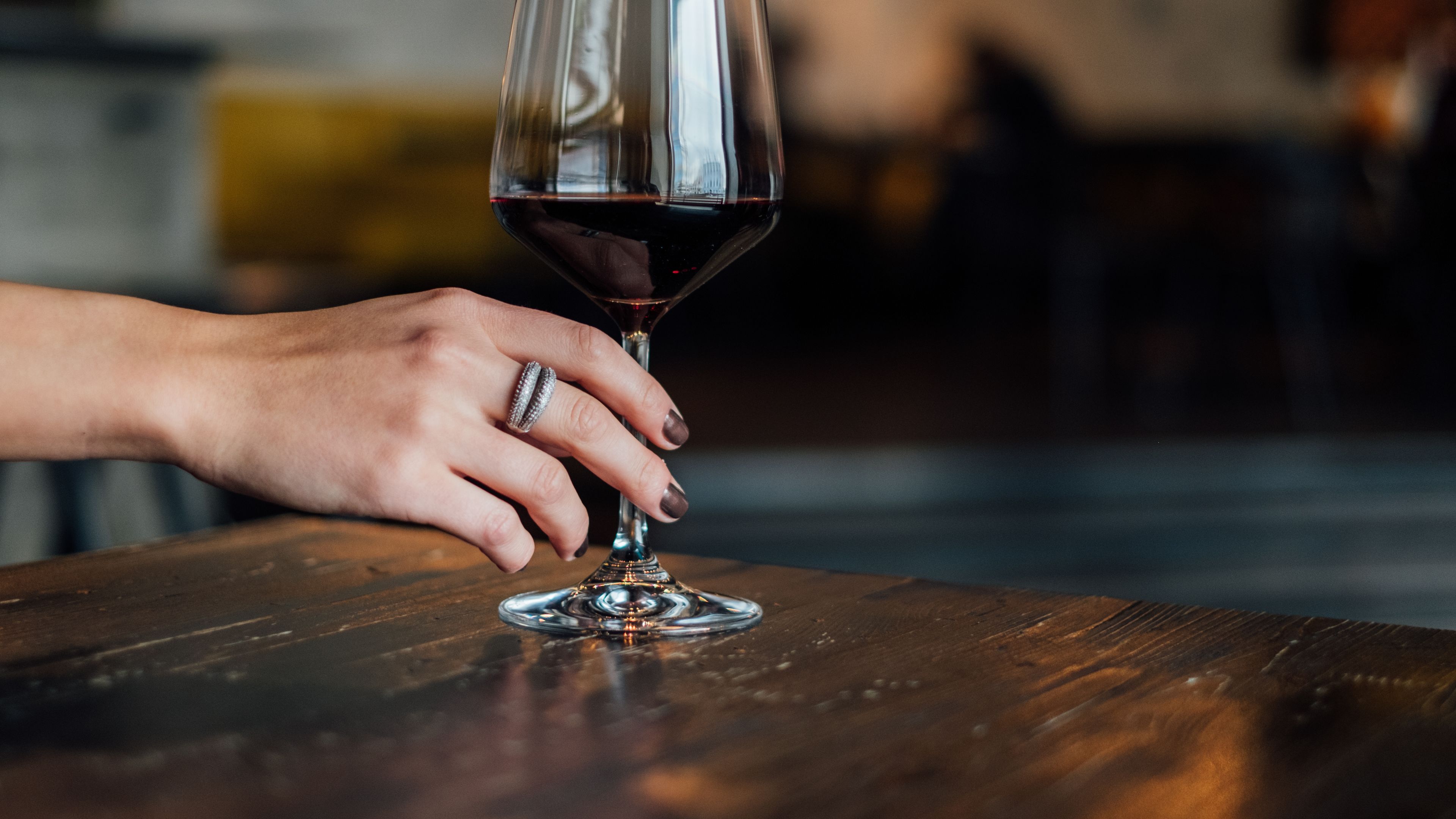 A hand holding a wine glass