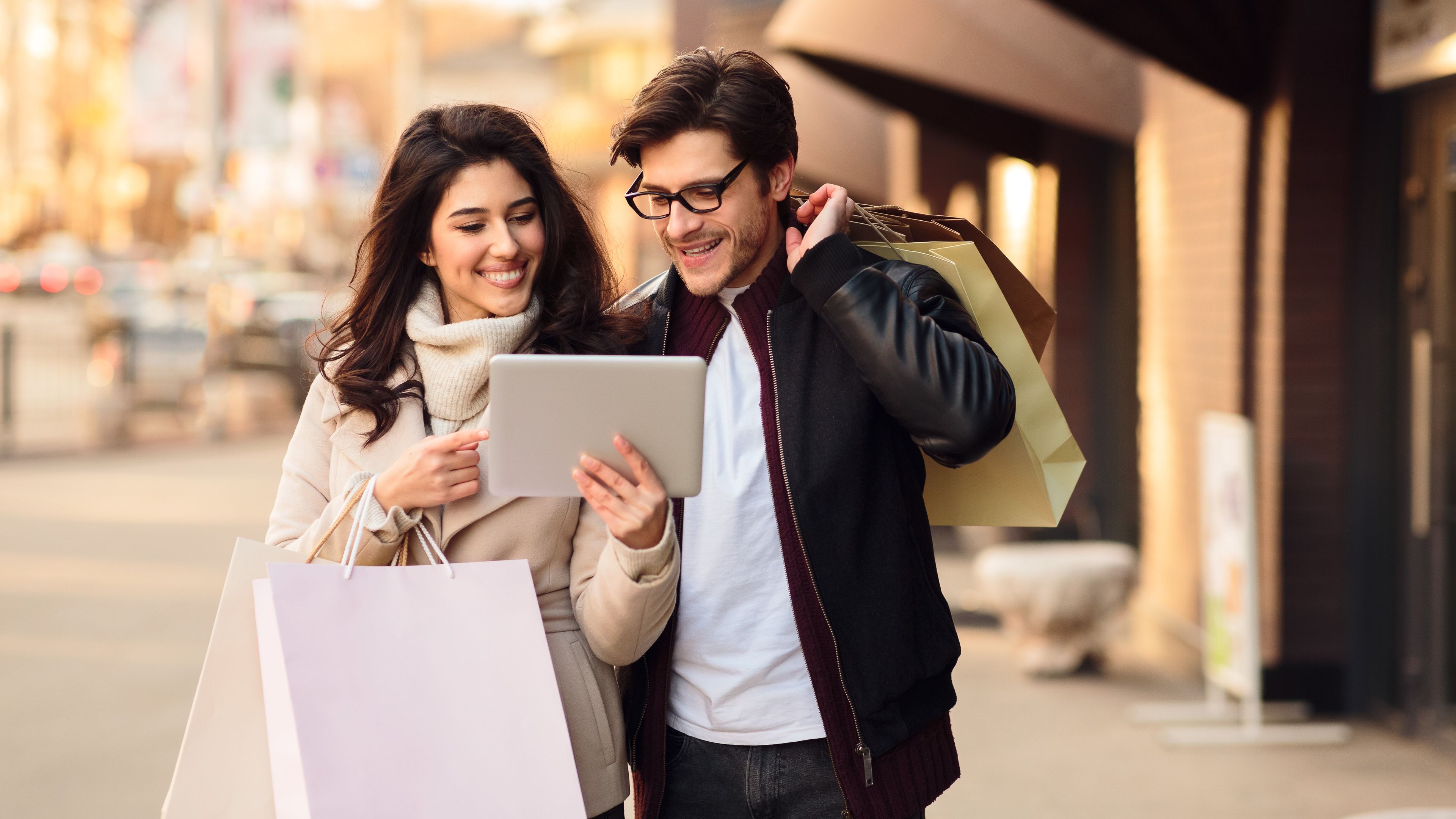 A man and woman holding iPad