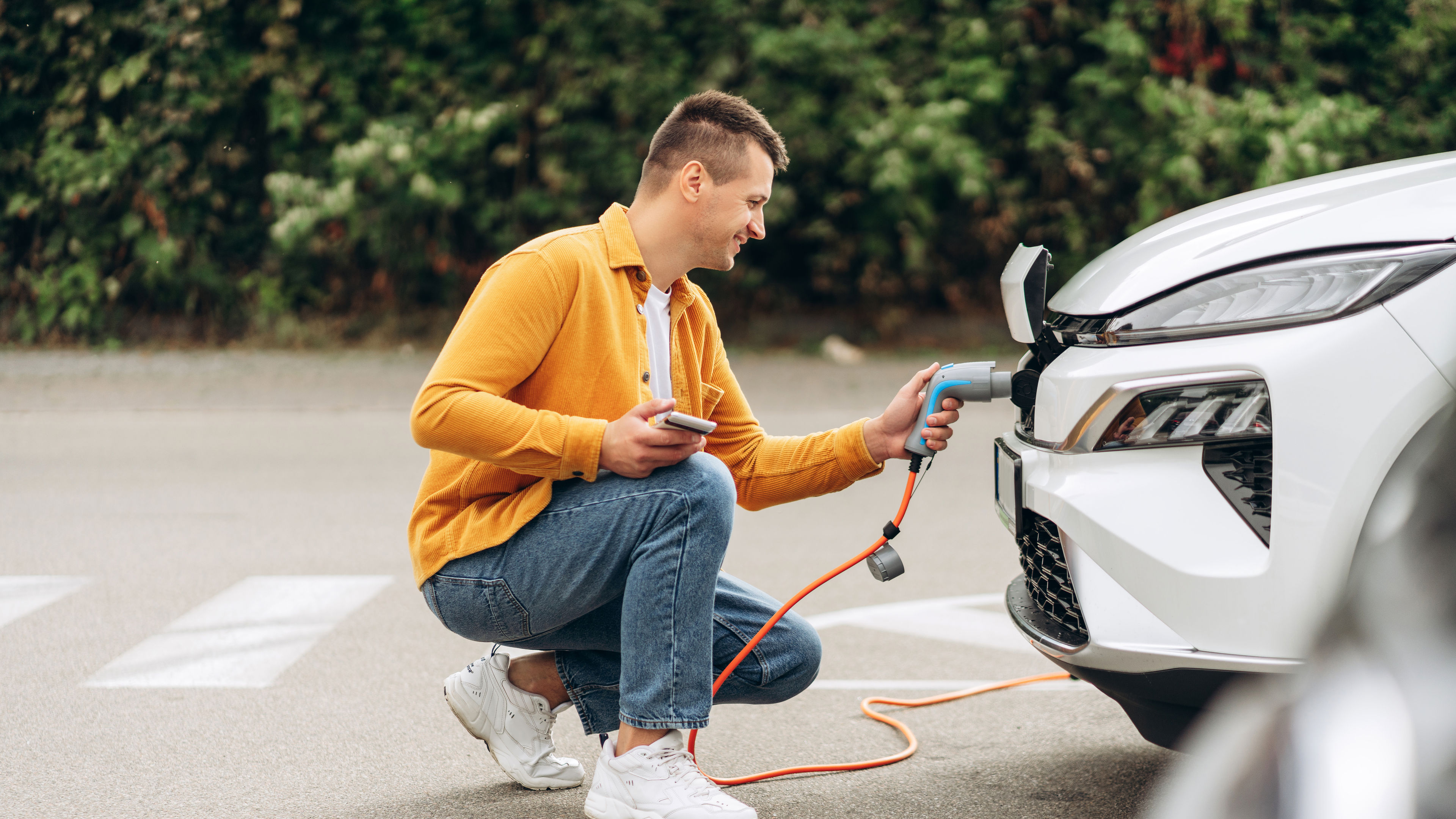 A man smiling and charging the car