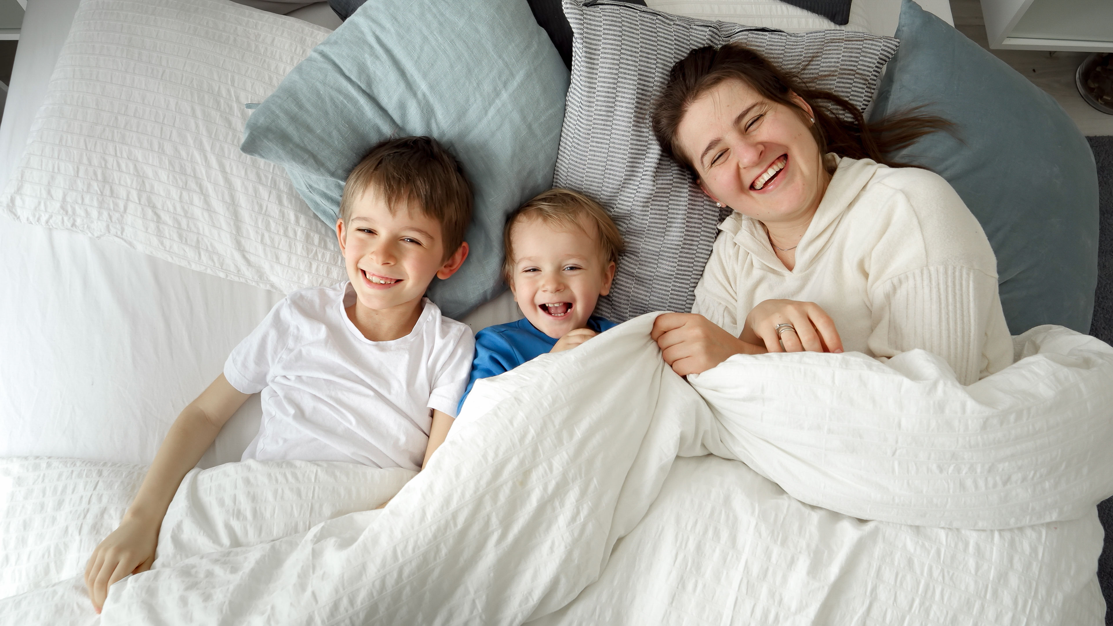 A mother with her children lying on a bed