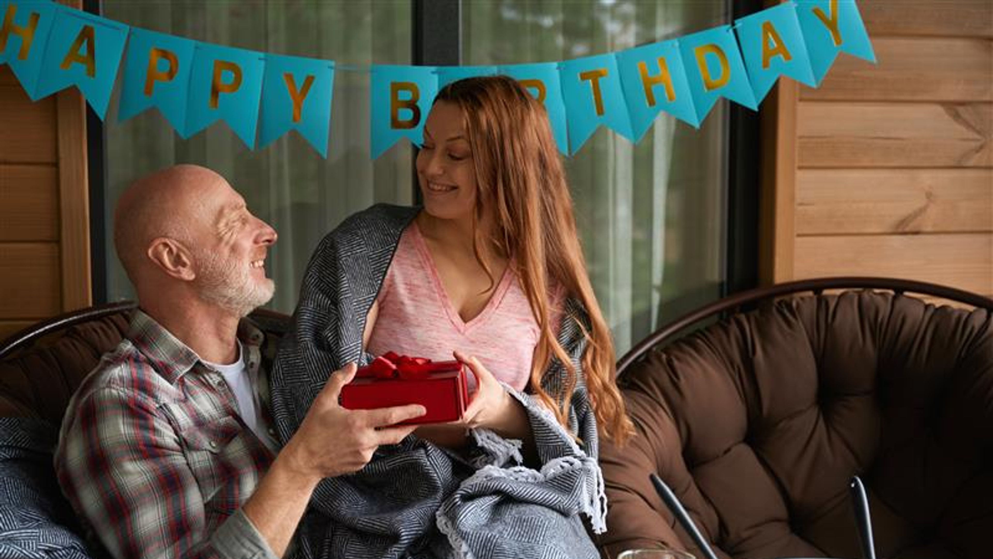A woman giving a gift box to her partner on birthday