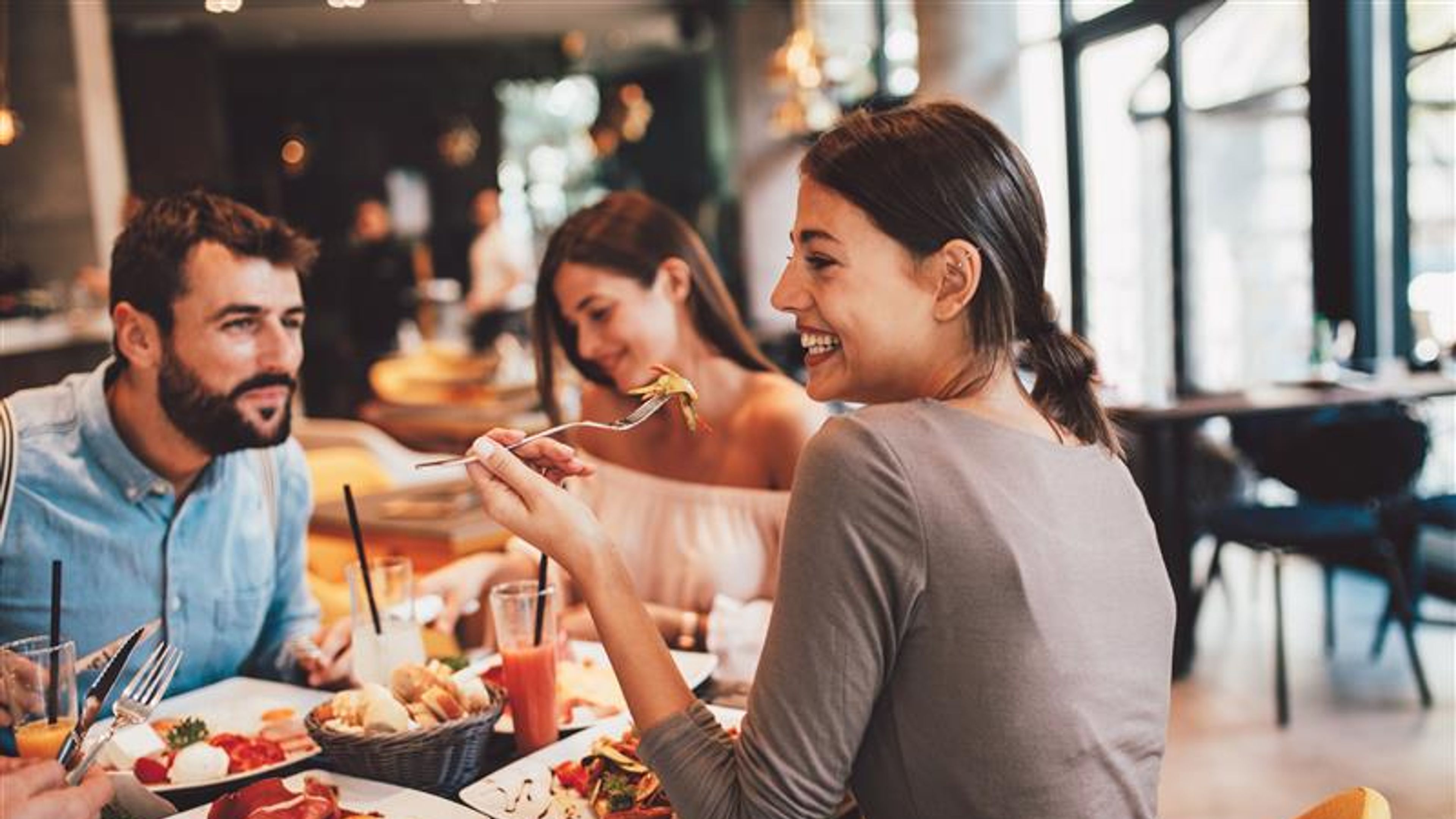 A woman happily eating a salad