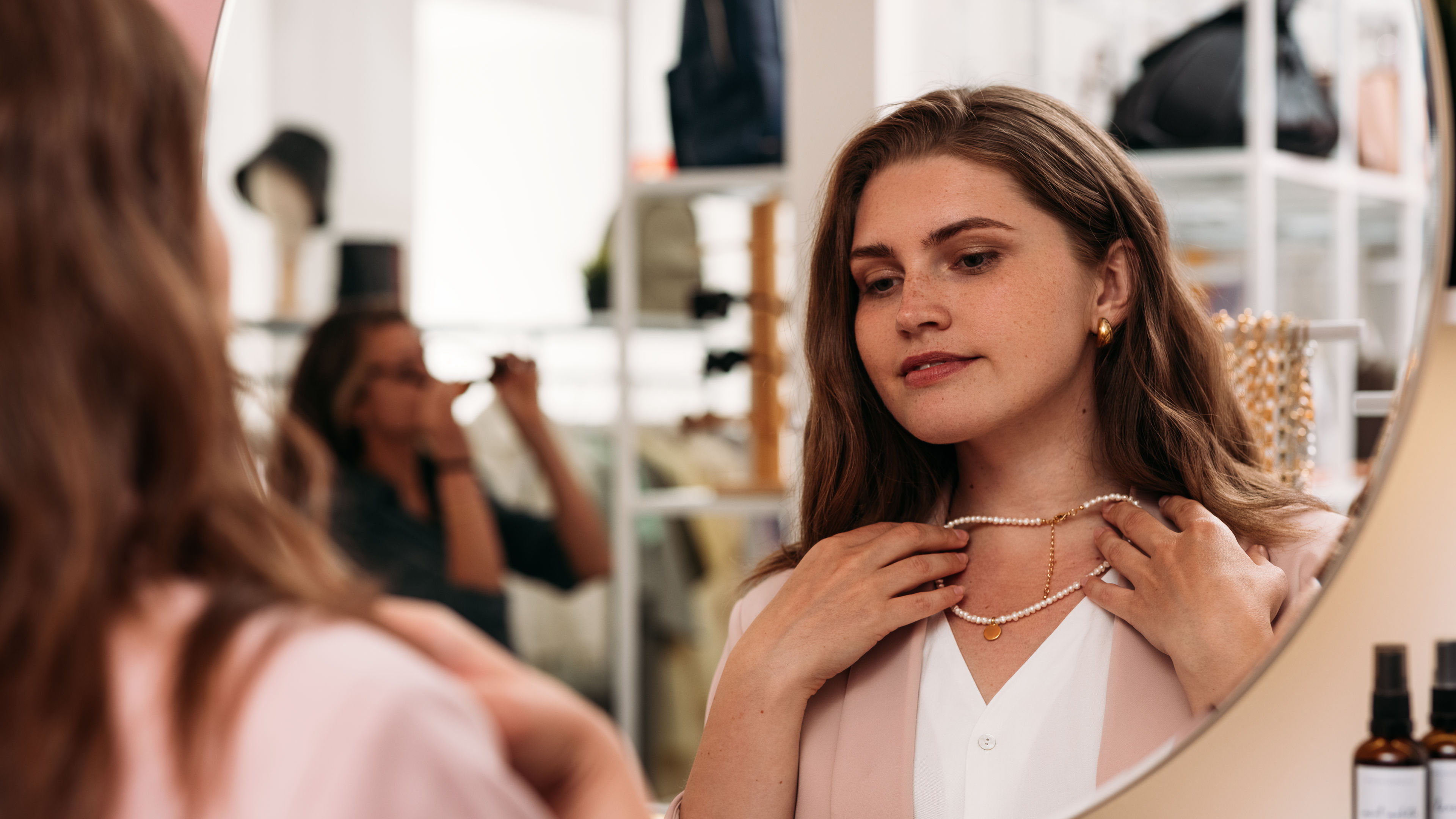 A woman holding a necklace. 