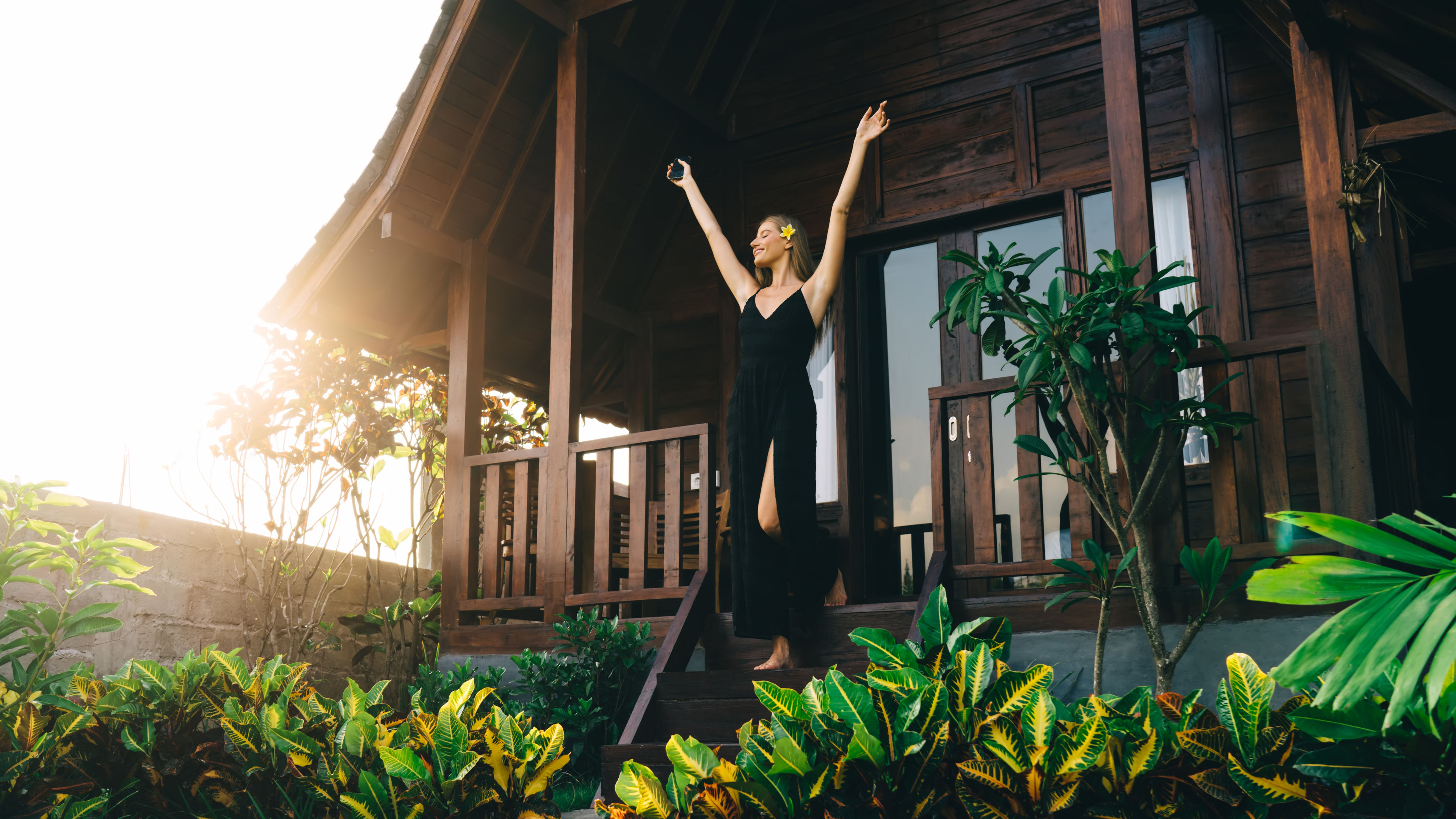 A woman in black dress standing on balcony