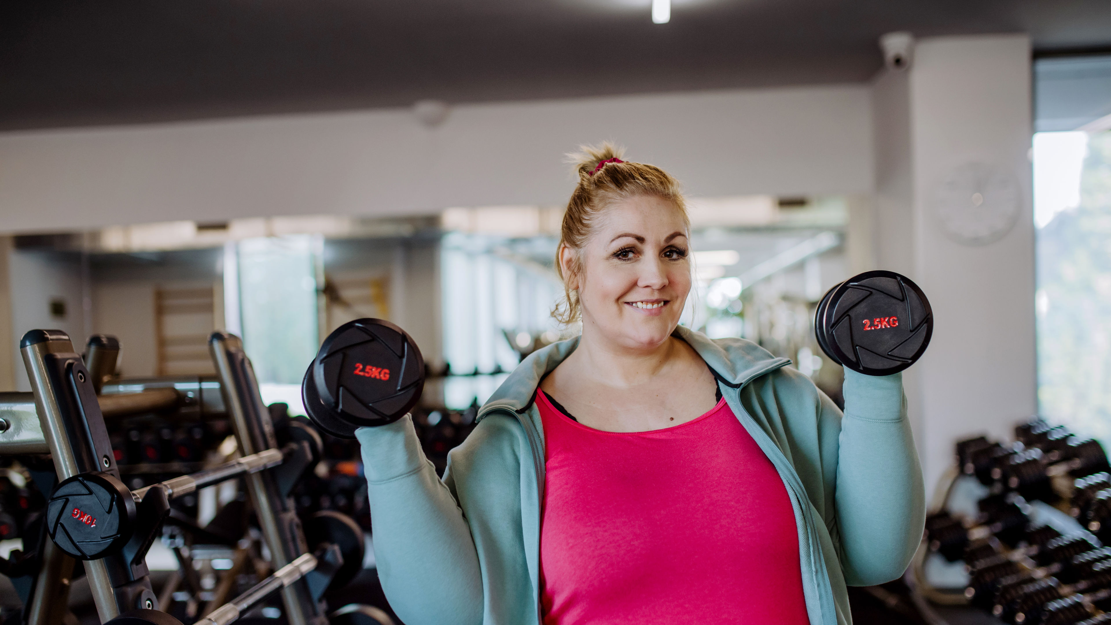 A woman lifting dumbbells in gym