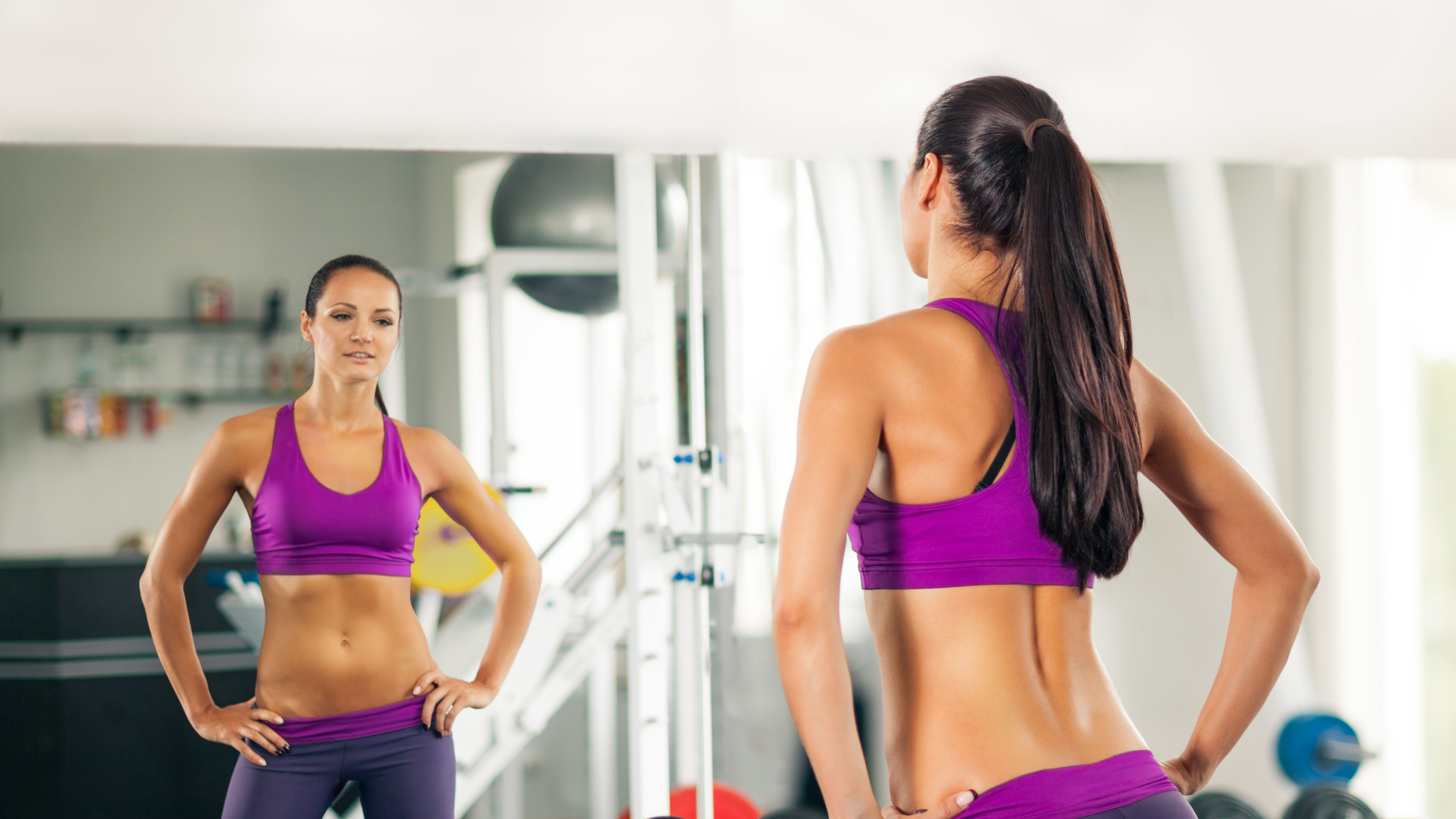 A woman wearing sportswear looking at a mirror 