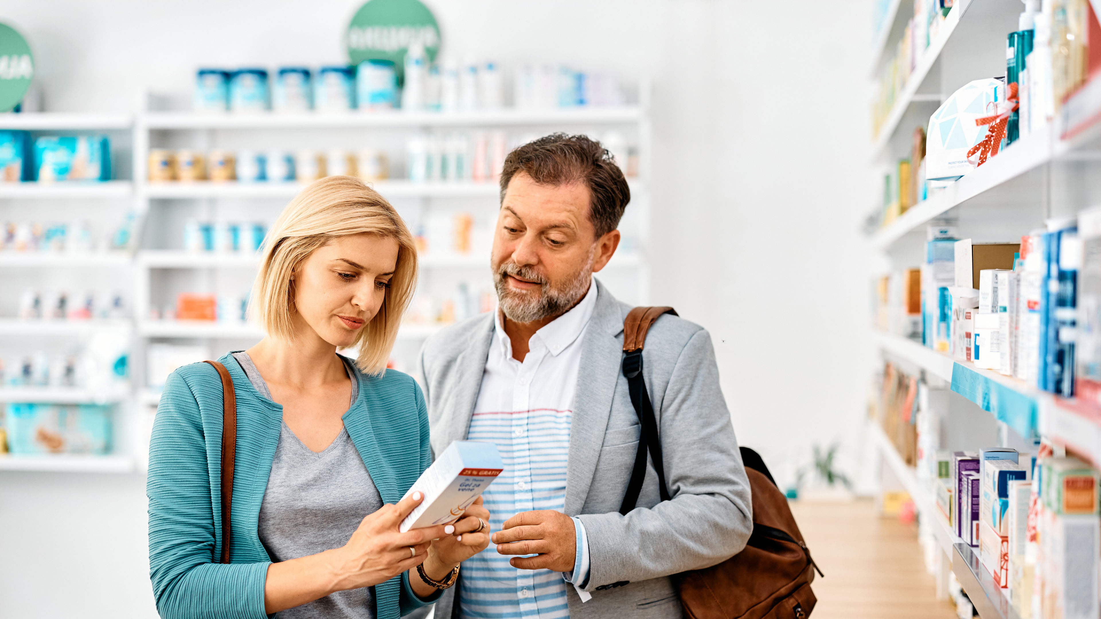 Couple reading label on nutritional supplement. 