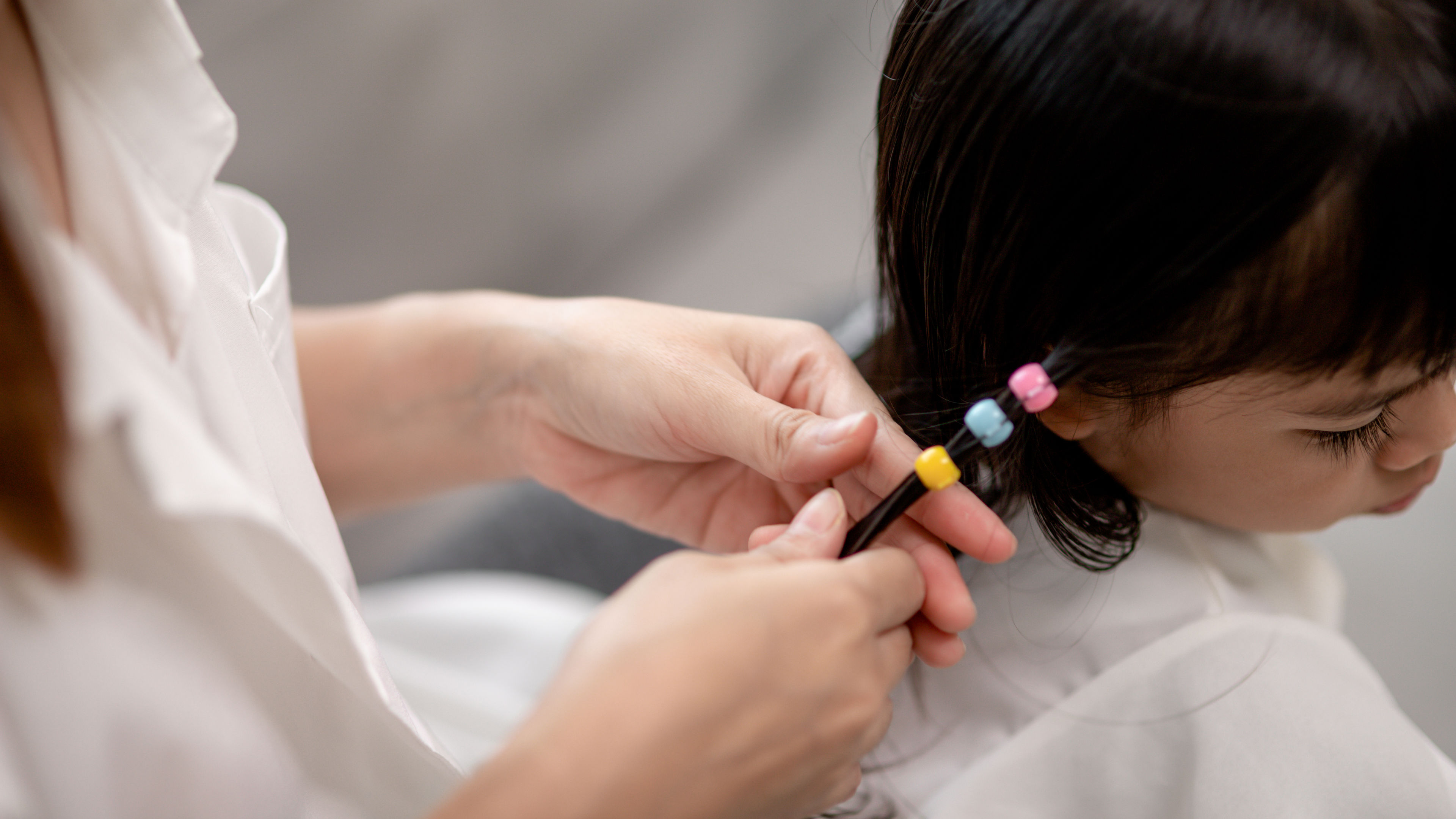 Fixing hair clip on a girl’s hair