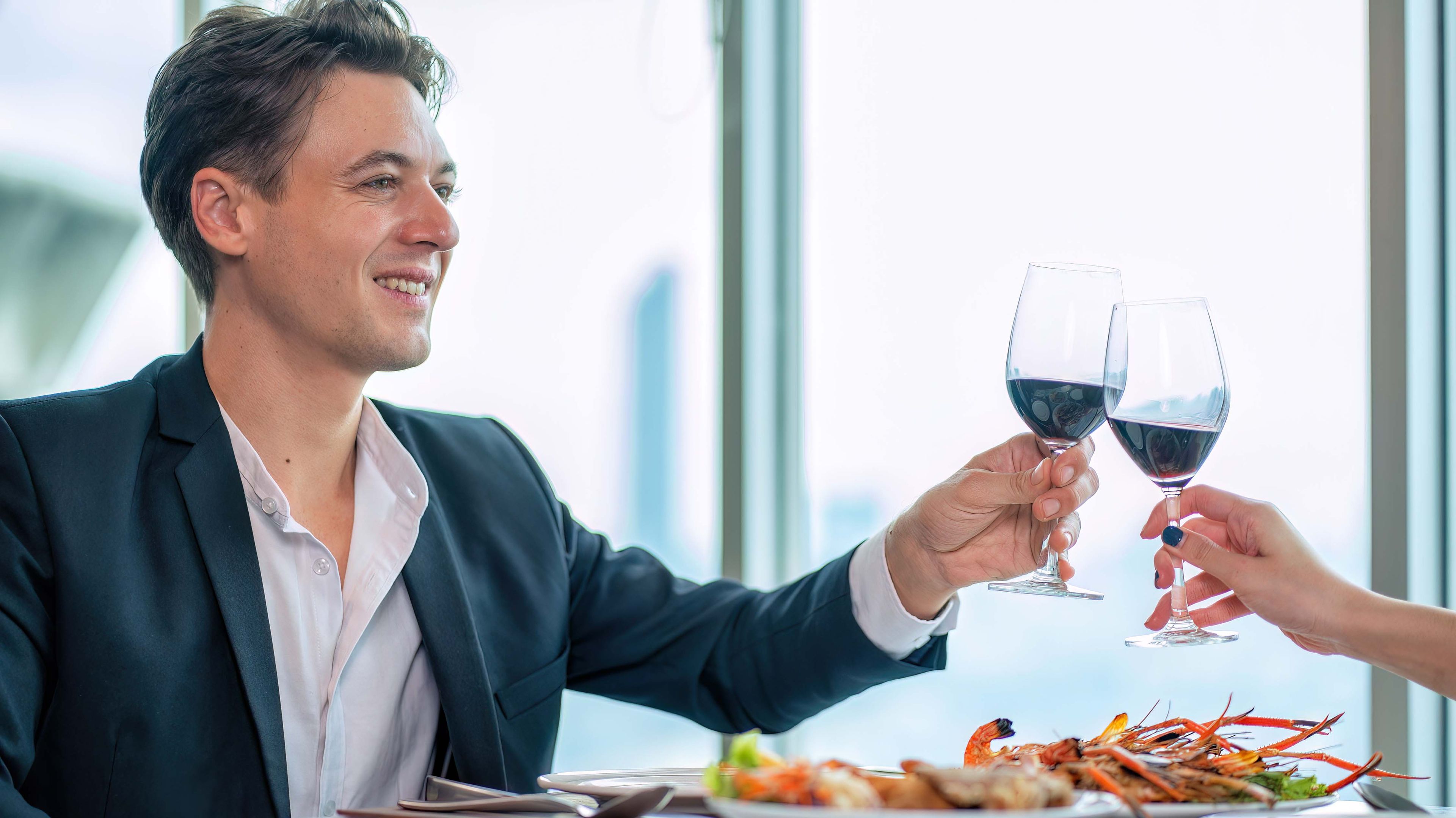 Happy man holding a glass of red wine