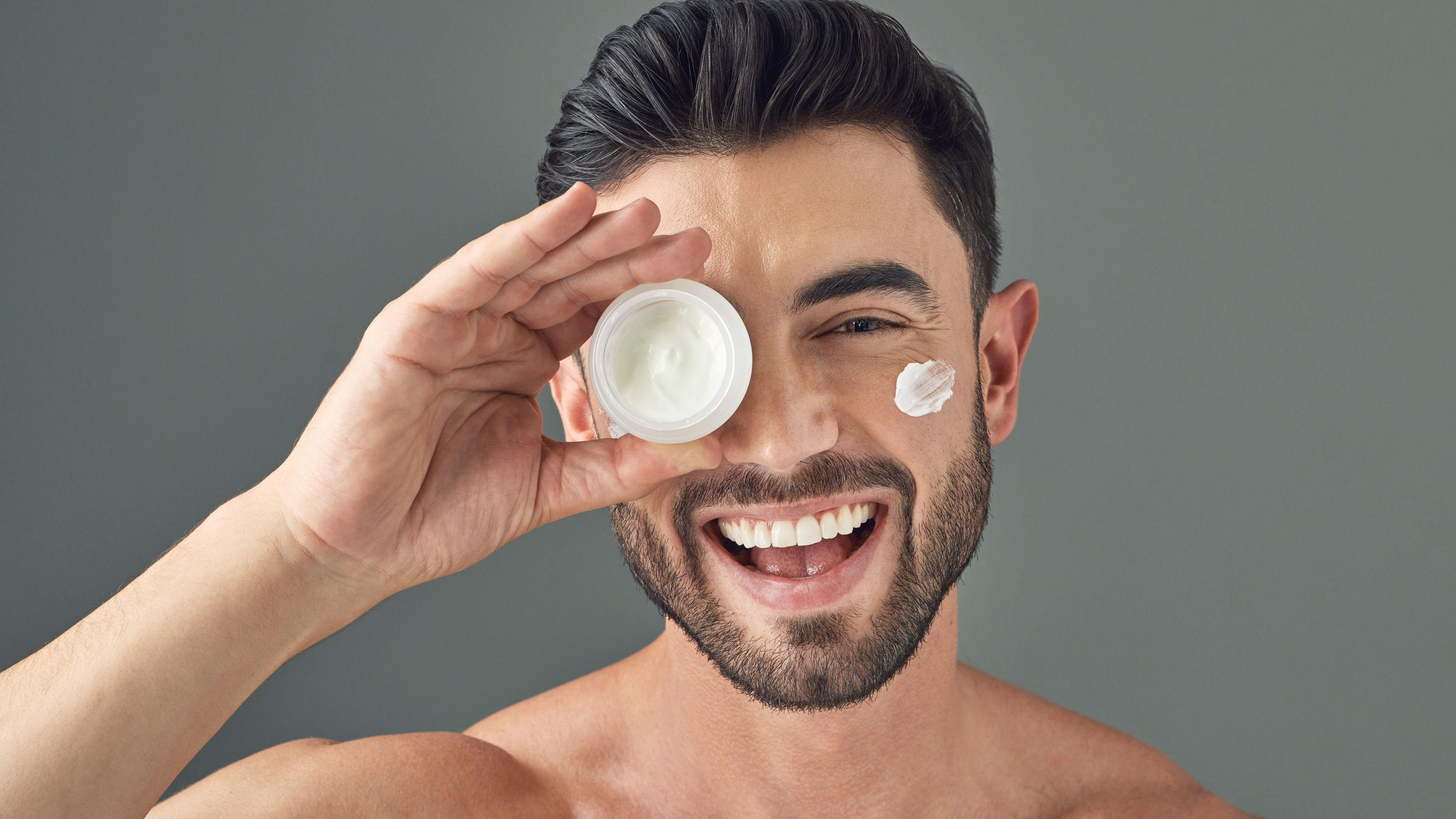 Man holding up a skincare product 

 