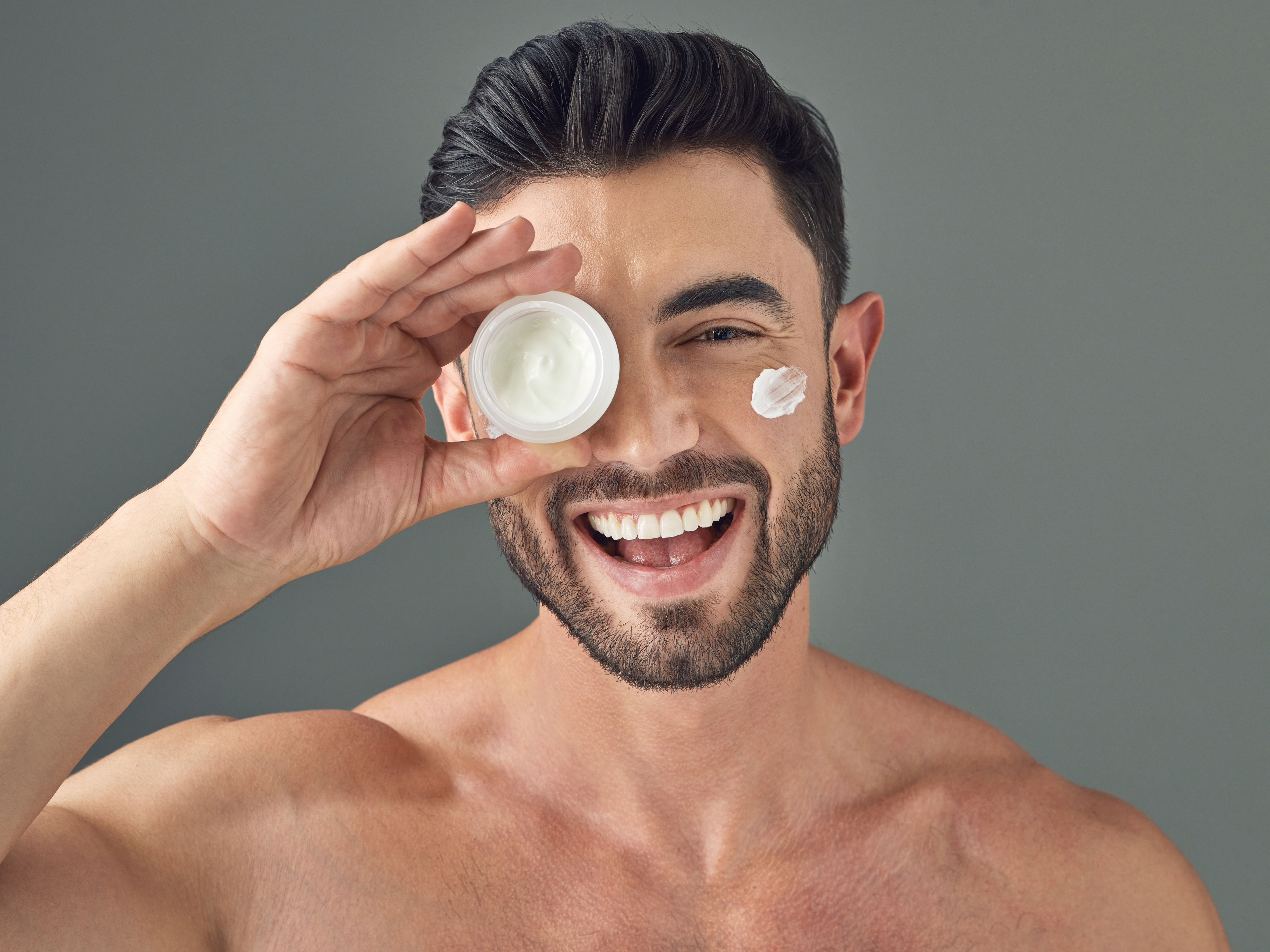 Man holding up a skincare product 