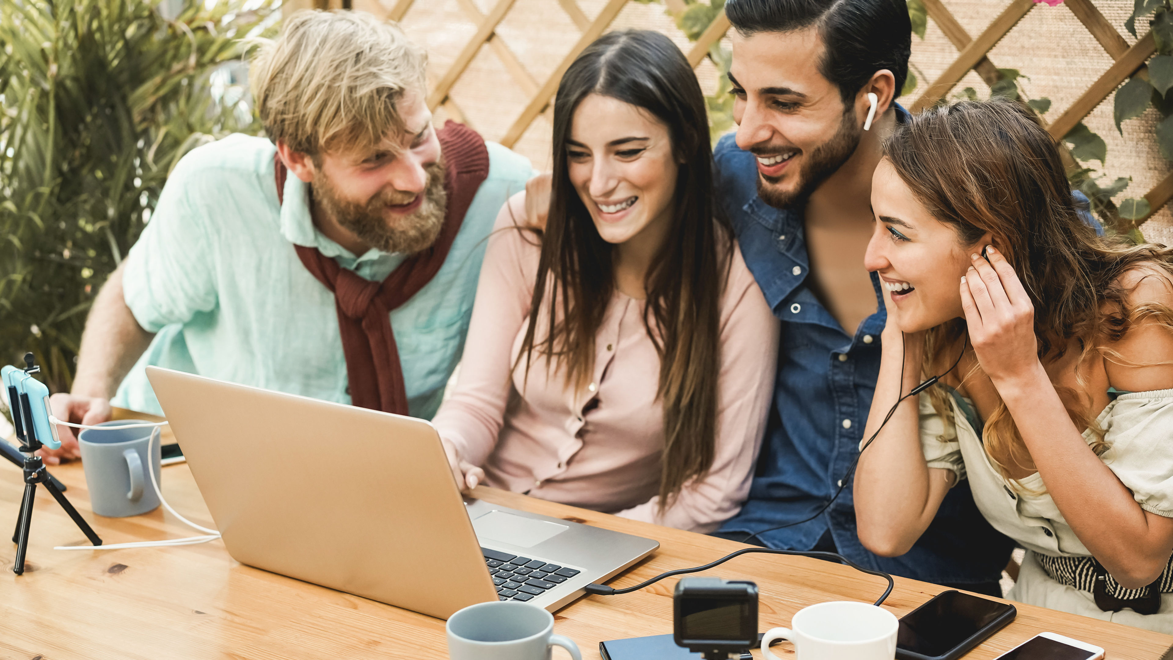 Smiling friends sharing a laptop via USB-C hub connection
