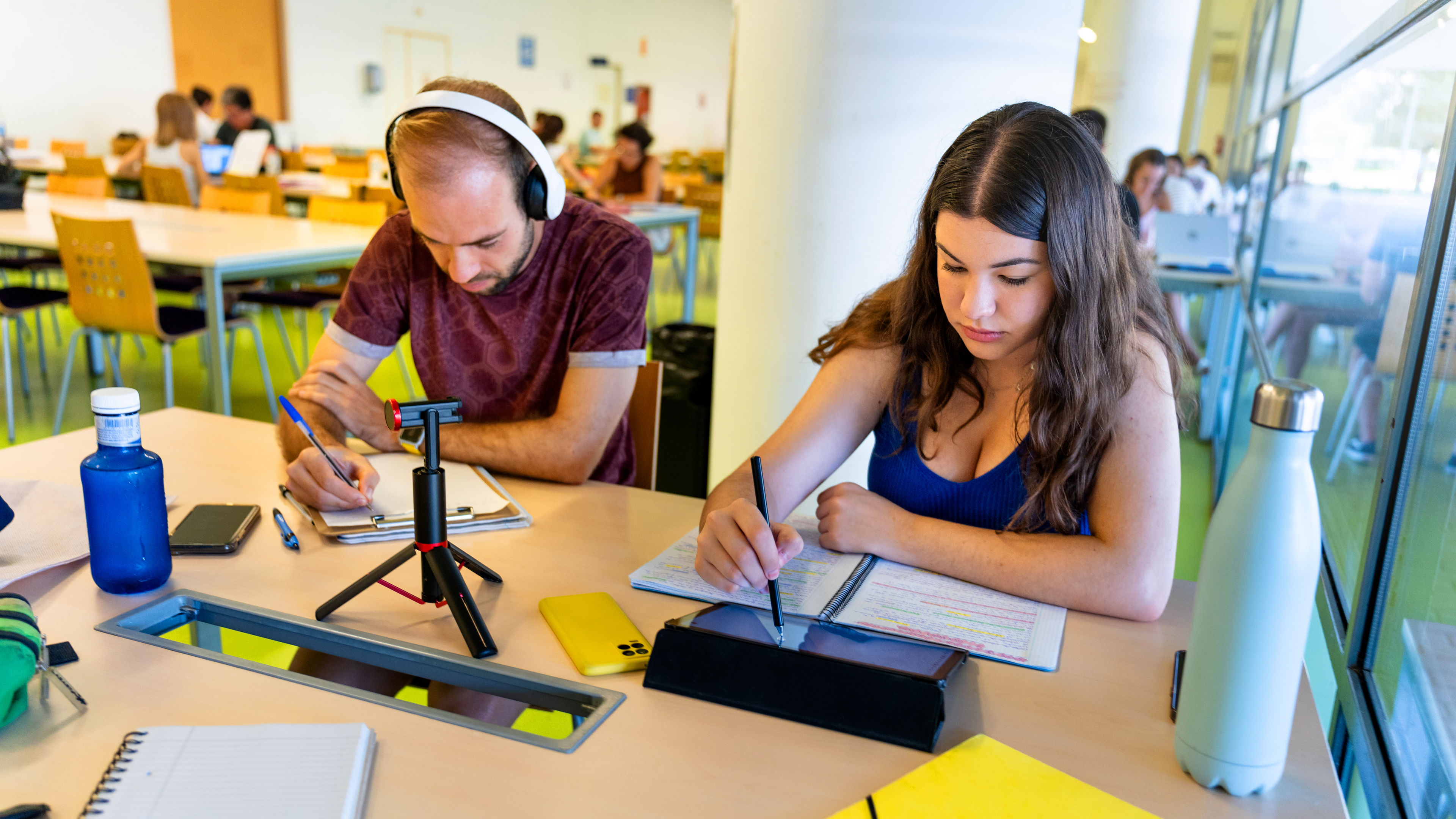 Two students studying using digital tools