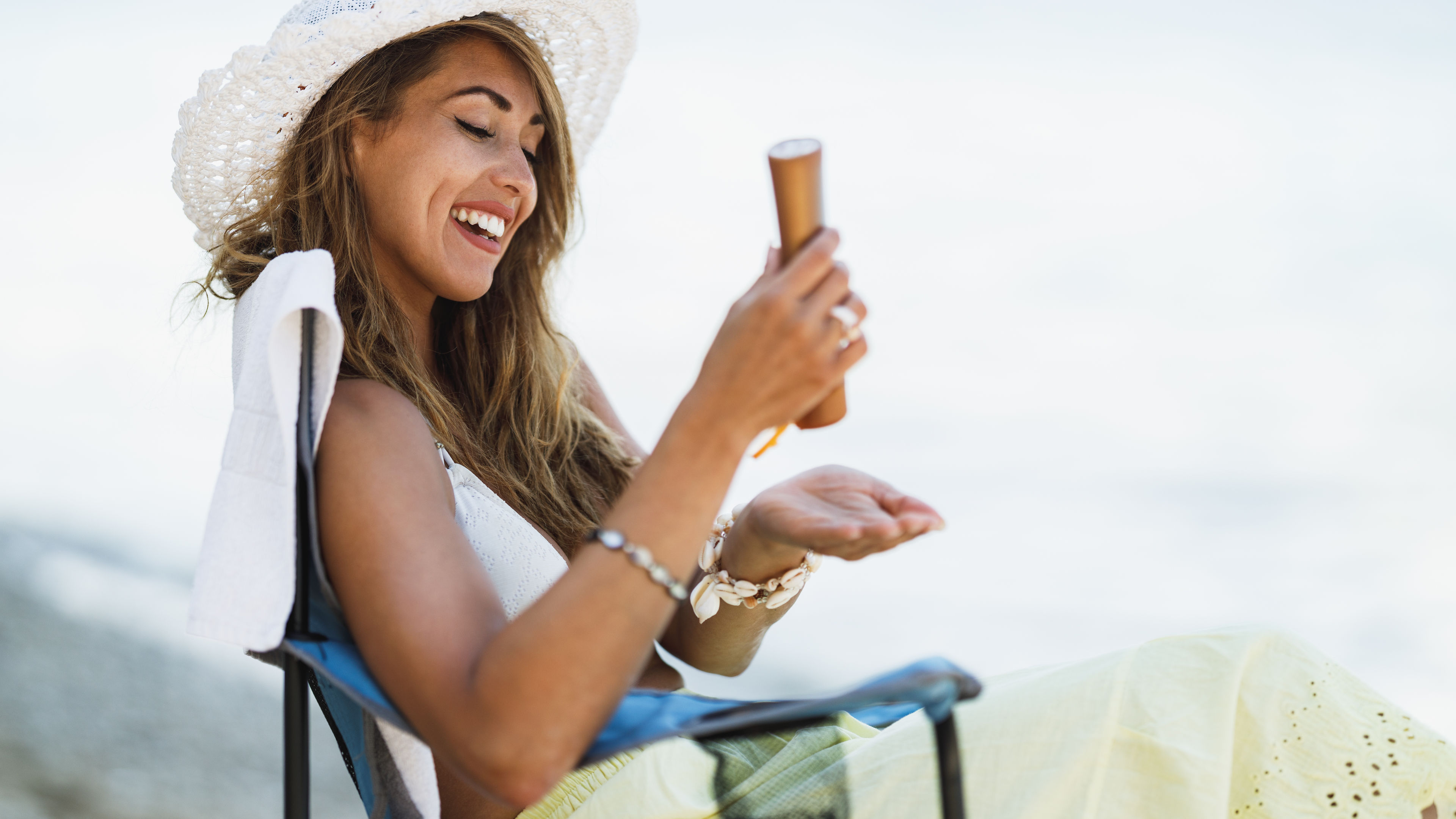Woman applying sunscreen at the beach