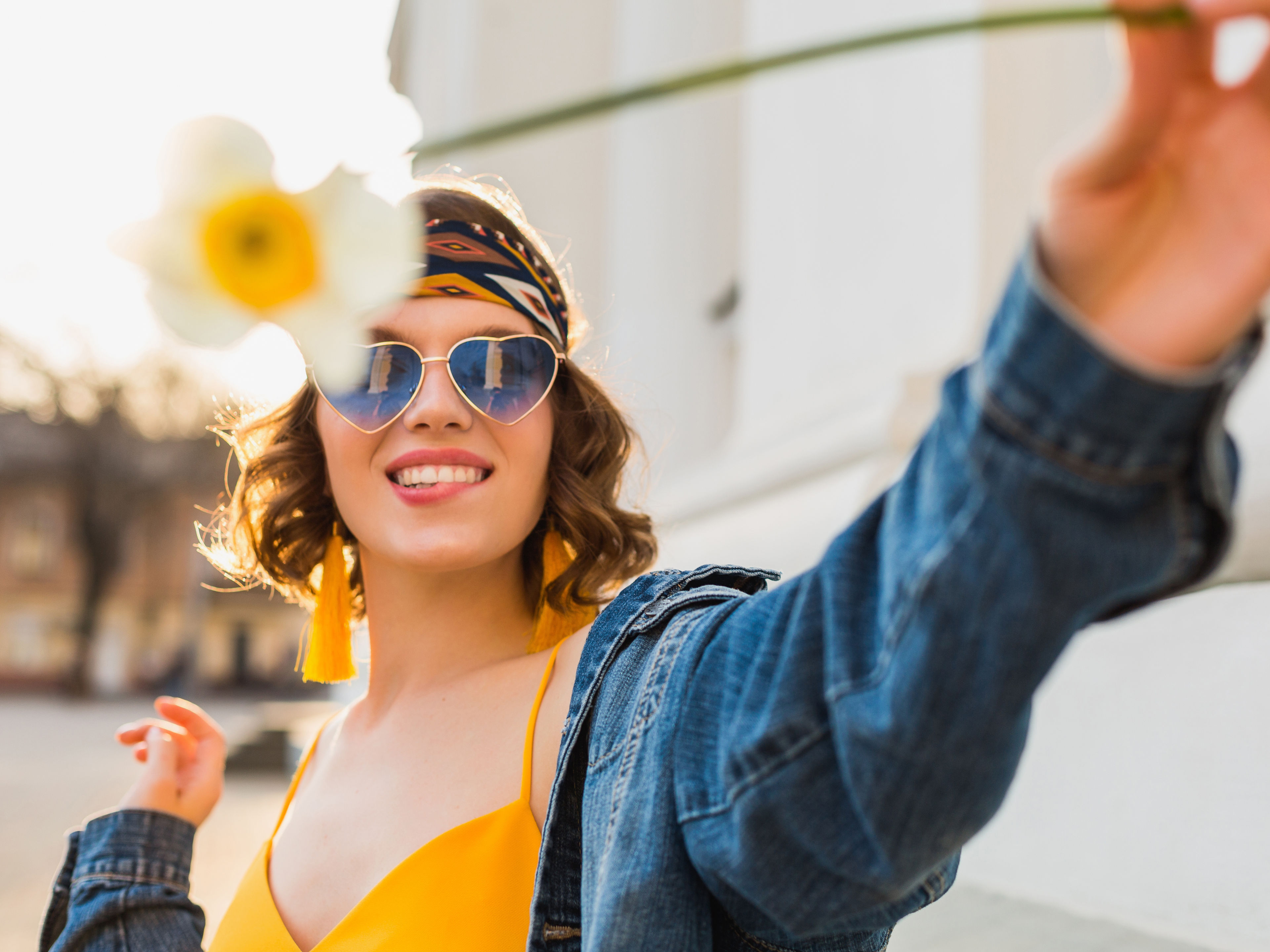Woman with sunglass holding flower 

 