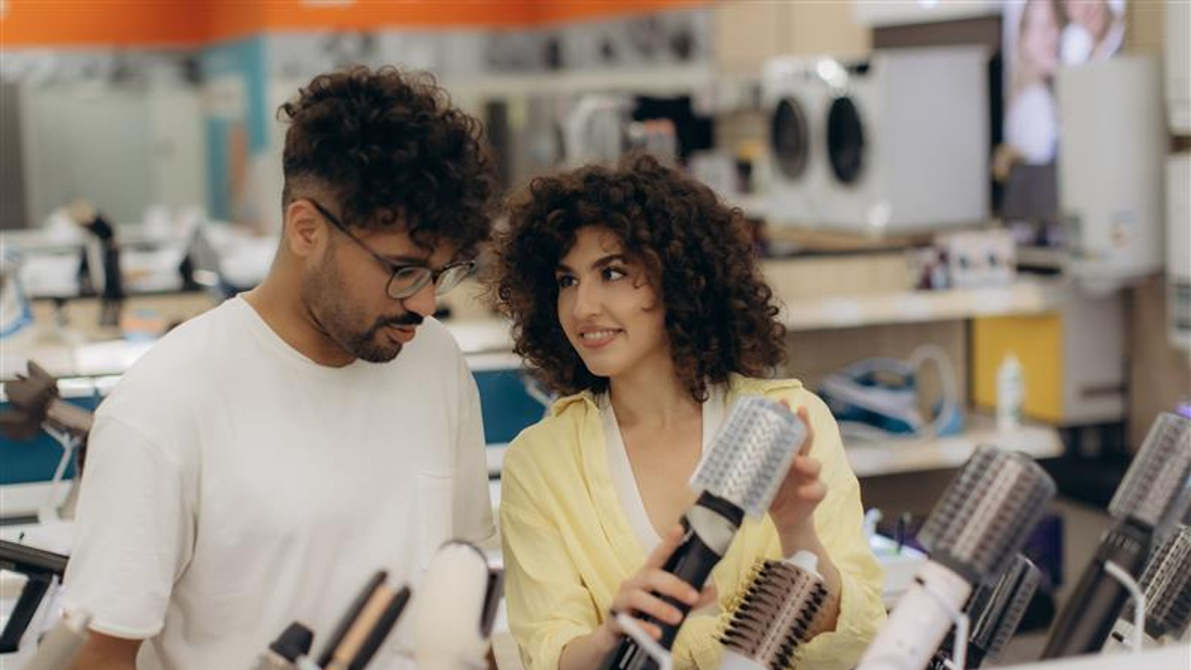 Young Couple Shopping for Hair Styling Tools in Electronics Store
