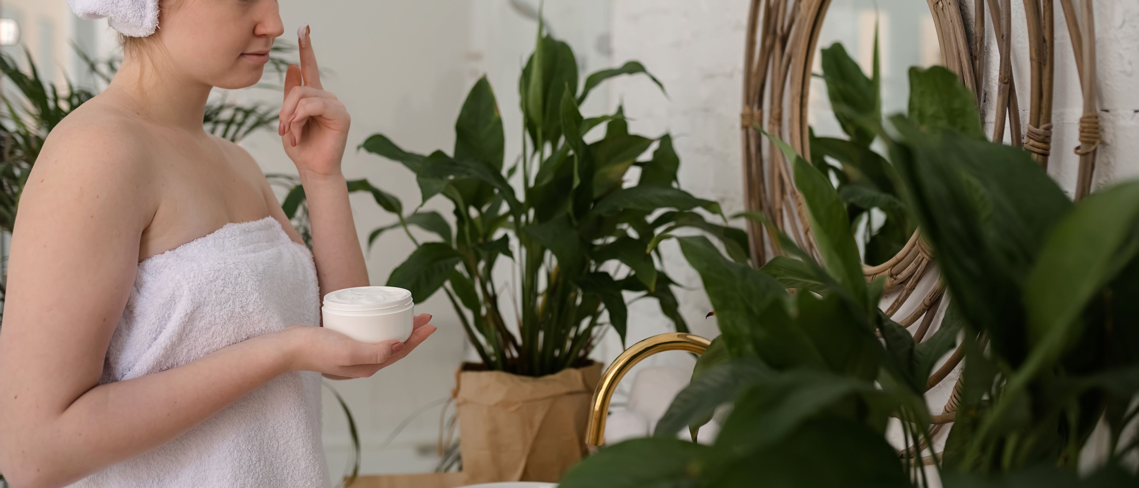 Young woman applying the cream to her face